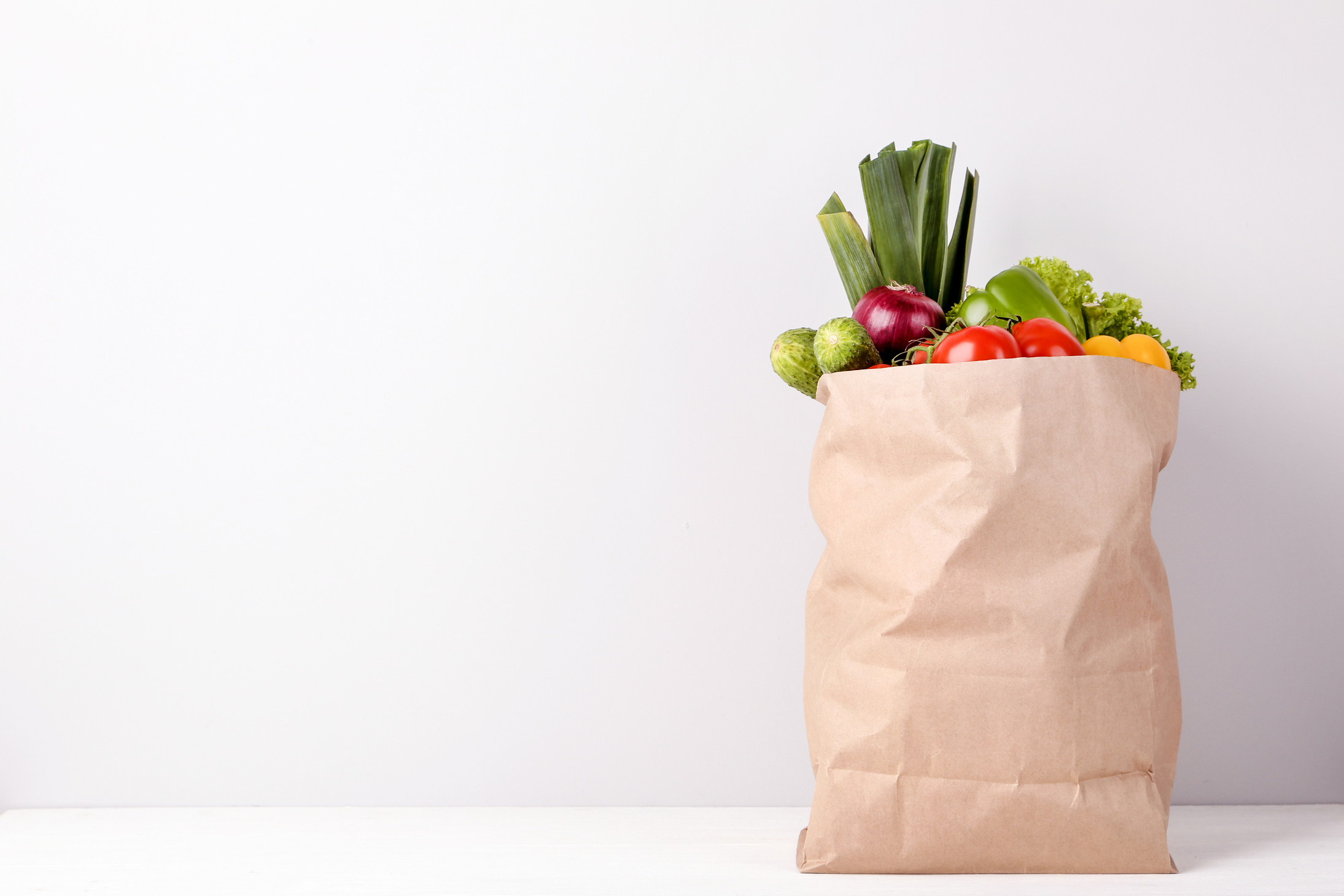 Grocery shopping bag with food on gray background